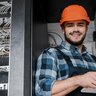 Ein Elektroniker der in einem Serviceraum ein Tablet bedient