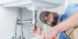 Ein Monteur unter einem Waschbecken